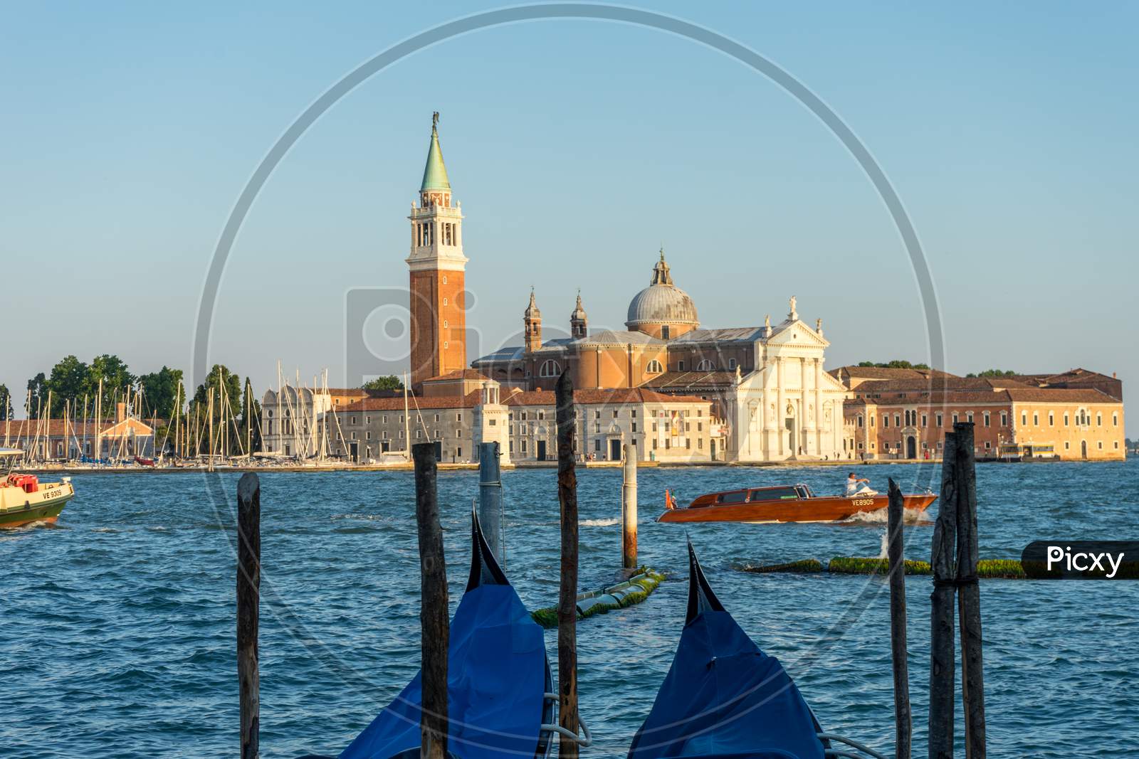 Venice, Italy - 30 June 2018: Gondolas Moored By Saint Mark Square With San Giorgio Di Maggiore Church In The Background In Venice, Italy