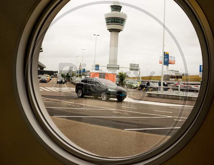 Amsterdam, Schiphol - 22 June 2018: The Airport Tower Viewed Through A Circular Glass Window