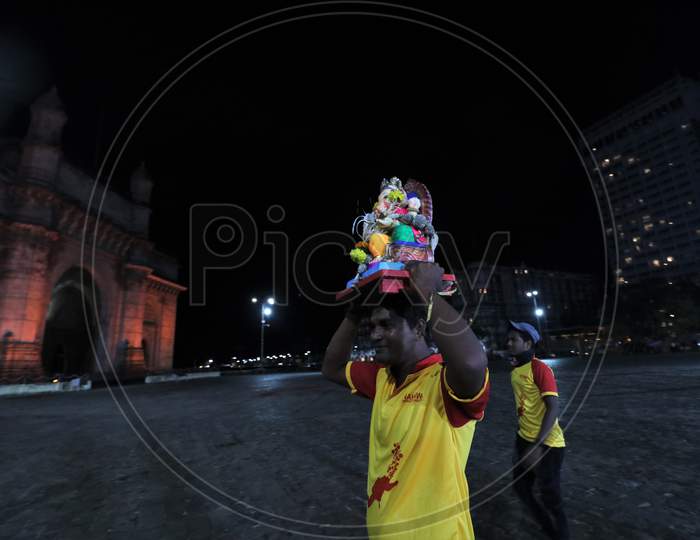Volunteers carry an idol of Hindu God Ganesha, to immerse in the Arabian Sea, marking the end of the 10-day long Ganesh Chaturthi festival at the Gateway of India, in Mumbai, India on September 1, 2020