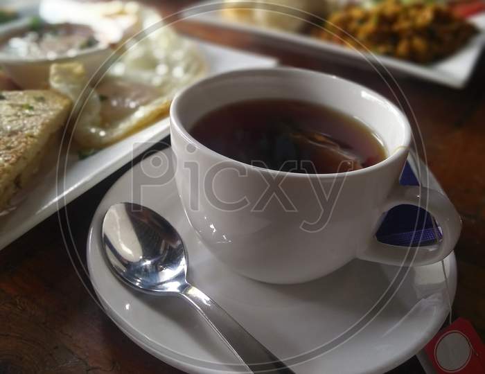 Black tea in a white cup on breakfast table