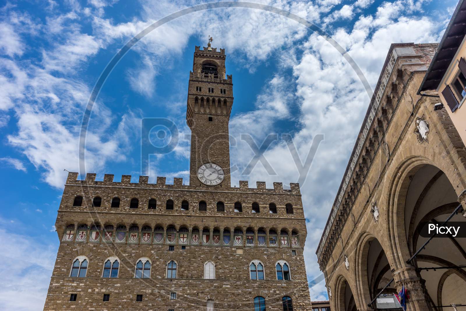 Italy,Florence, Palazzo Vecchio, A Large Tall Tower With A Clock On The Side Of Palazzo Vecchio