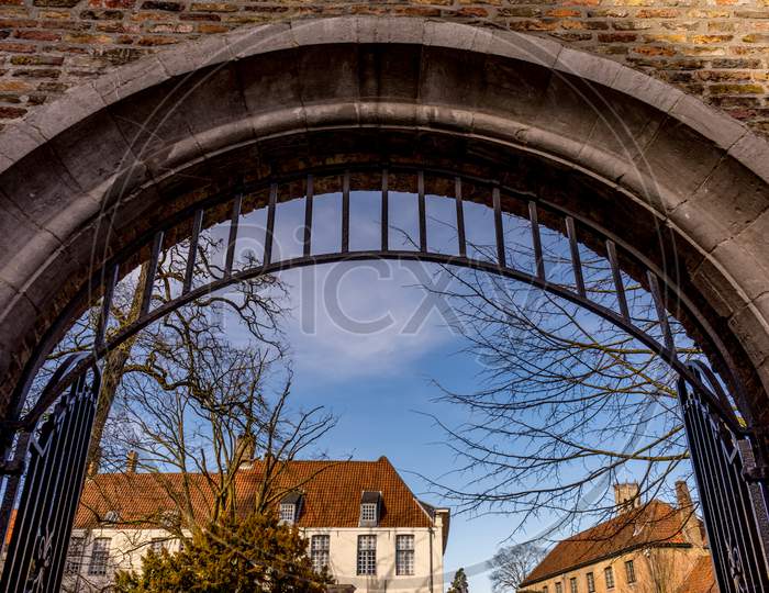 Belgium, Bruges, A Arch Under A Blue Sky