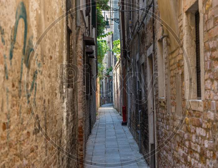 Italy, Venice, A Narrow Street In Front Of A Brick Building