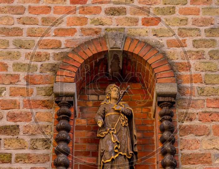 Belgium, Bruges, A Statue On A Brick Wall