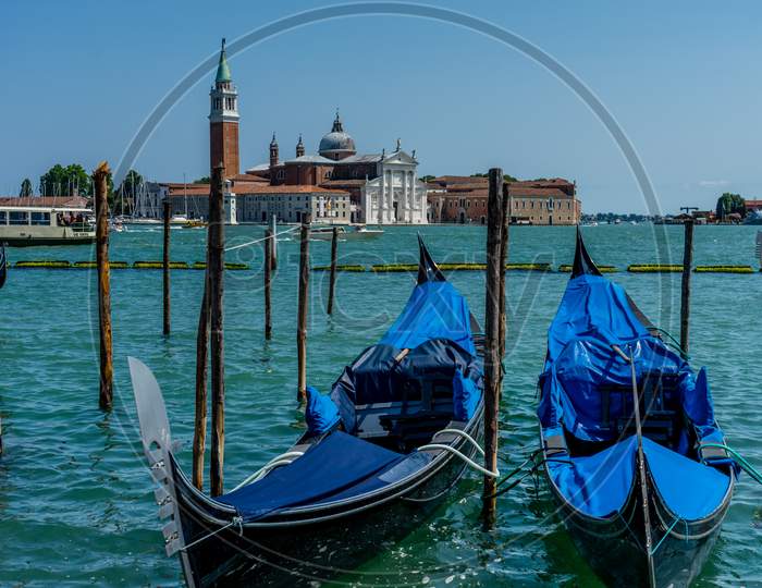 Venice, Italy - 01 July 2018: Gondolas Moored By Saint Mark Square With San Giorgio Di Maggiore Church In The Background In Venice, Italy
