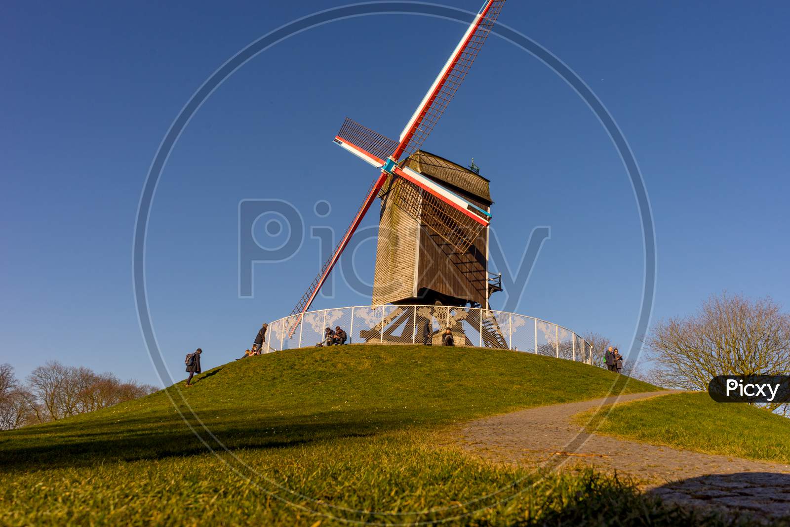 Belgium, Bruges, A Stone Path Leading To A Windmill