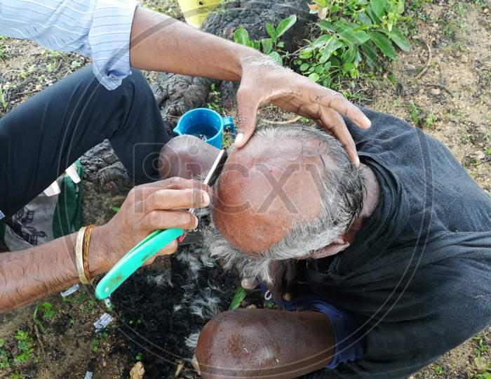 Old poor man saving head from the barber
