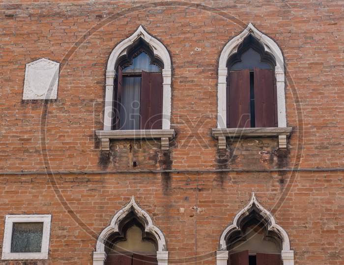 Italy, Venice, Ancient Windows On A Red Building