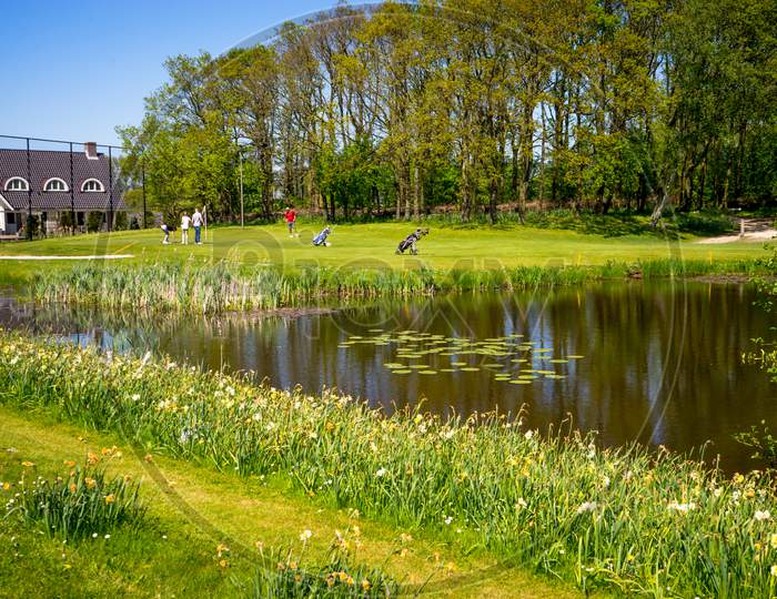 Lisse, Netherlands - 5 May 2018: People Playing Golf Near Water Pond At A Resort In Lisse