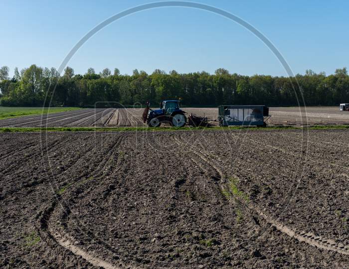Lisse, Netherlands - 5 May 2018: A Farmer Ploughing His Field Using A Tractor