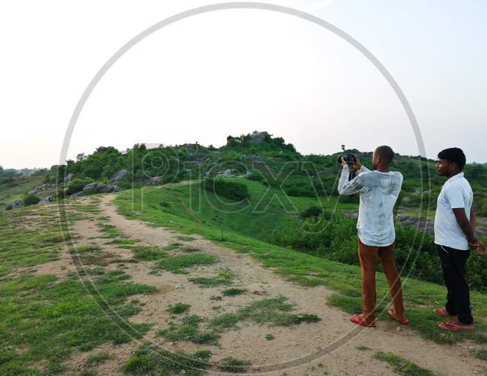 A man clicking the picture of nature and one man guiding