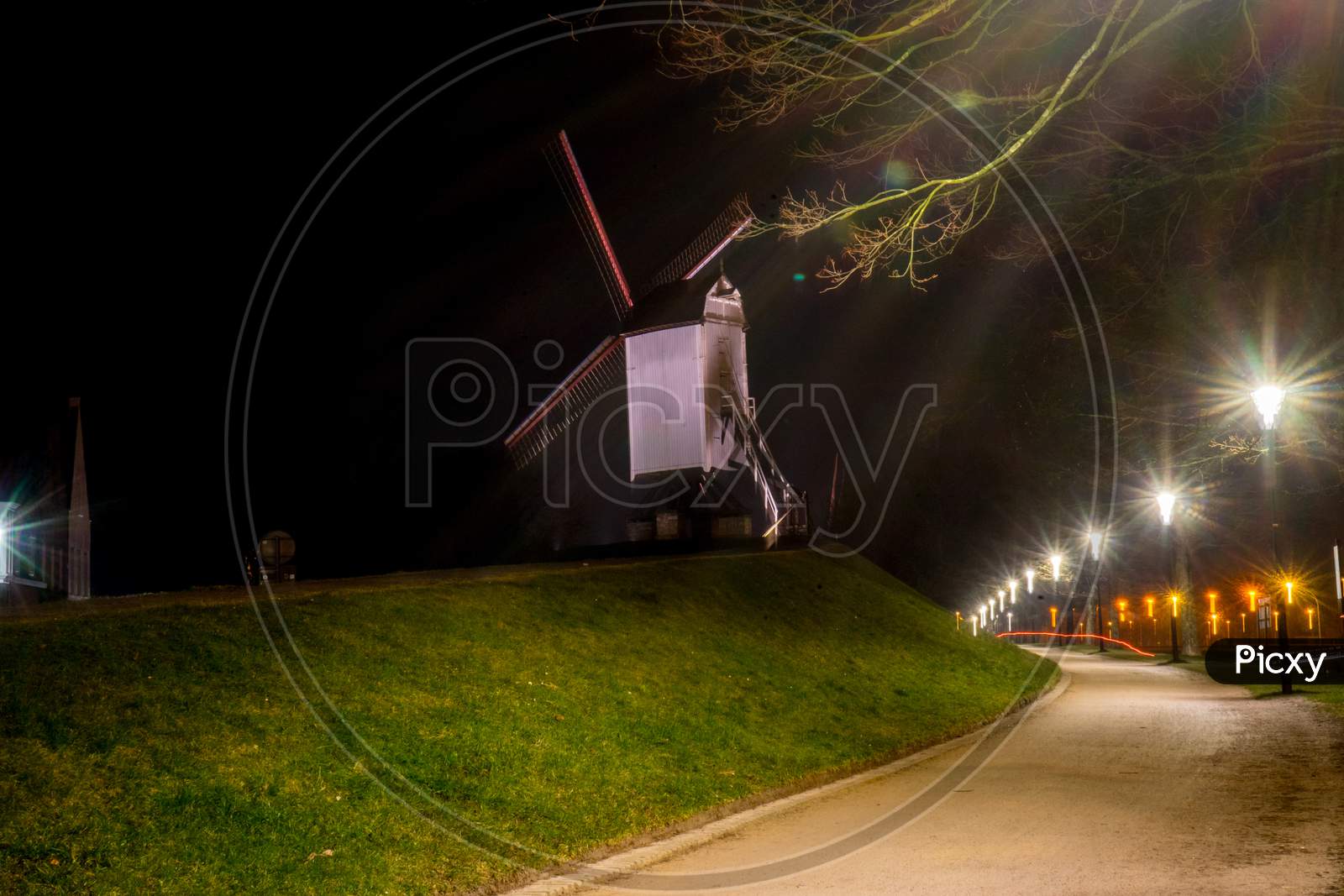 Belgium, Bruges, A Close Up Of A Street At Night With Windmill