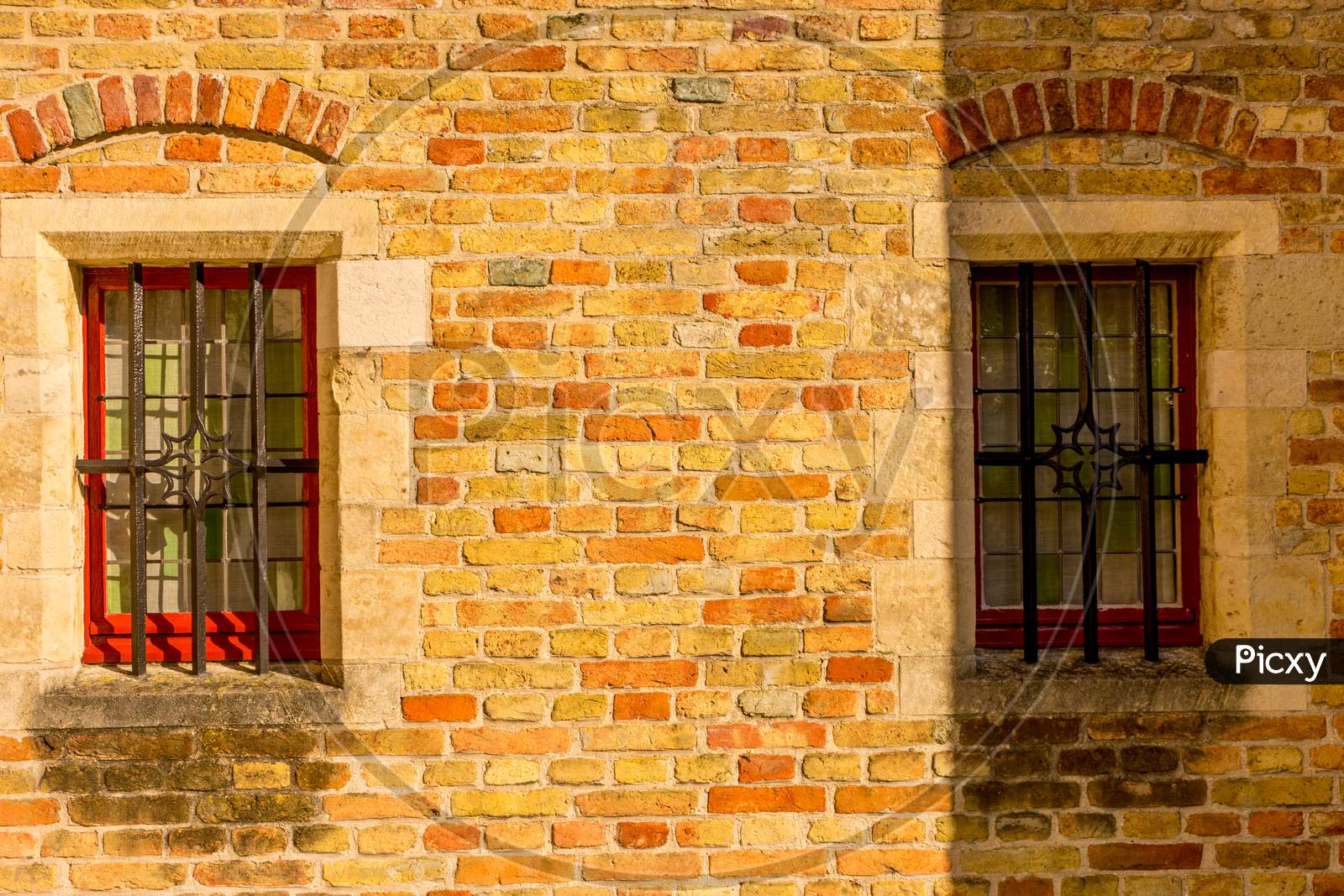 Belgium, Bruges, A Large Brick Building With A Red Window