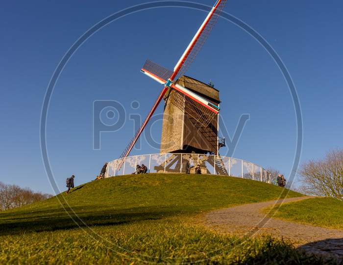 Belgium, Bruges, A Stone Path Leading To A Windmill