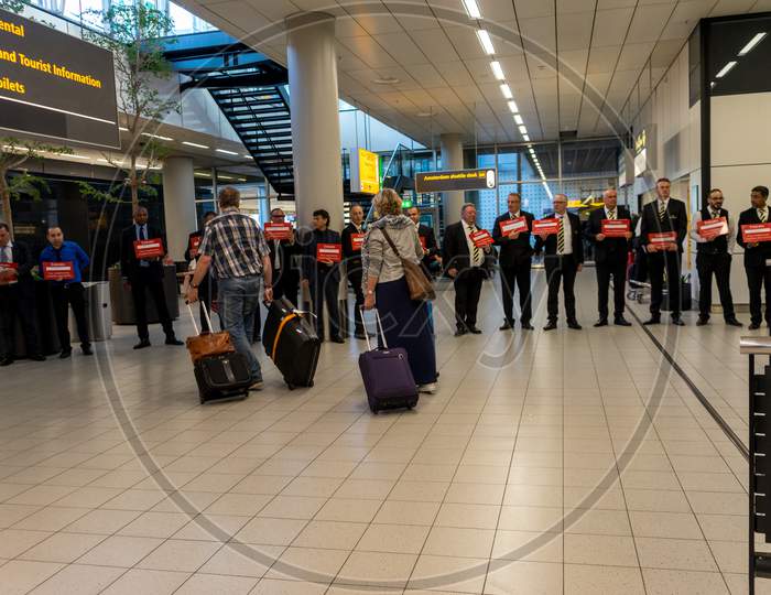 Netherlands, Amsterdam, Schiphol - 06 May, 2018: Passengers Walkign Towards Taxi Drivers For Emirate Flight