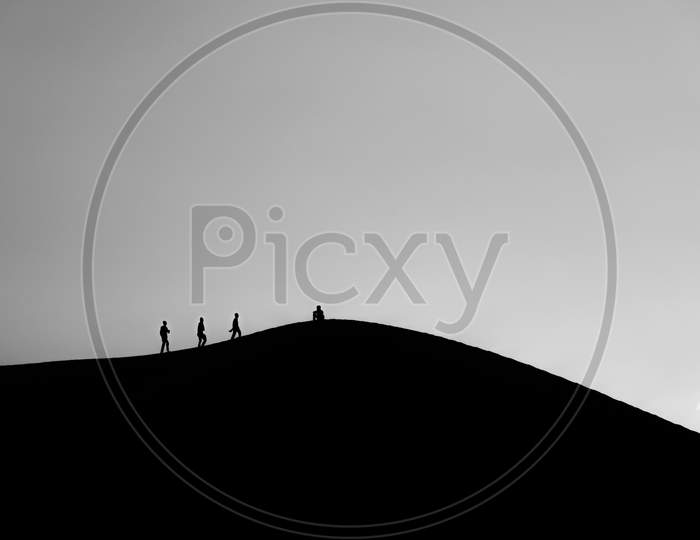 black and white picture of People walking on desert in silhouette