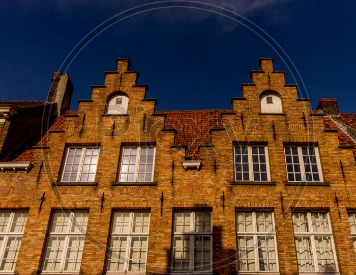 Bruges, Belgium - 17 February 2018: Gable On Top Of A Red Brick Building At Bruges