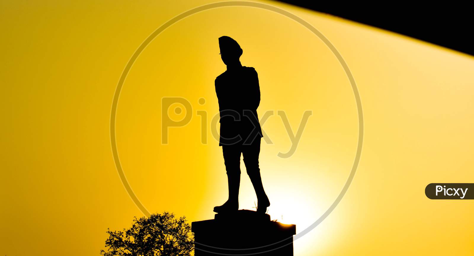 Subhash chandra bose statue in black yellow silhouette against sun
