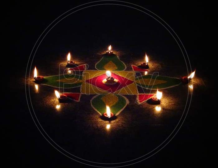 Celebrating diwali with rangoli, flowers and diya
