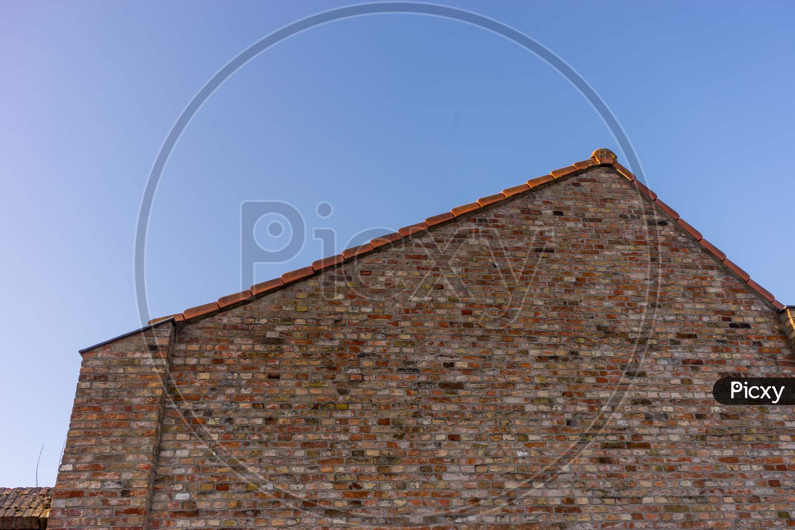 Belgium, Bruges, A Large Brick Building With Slanted Roof Red Bricks