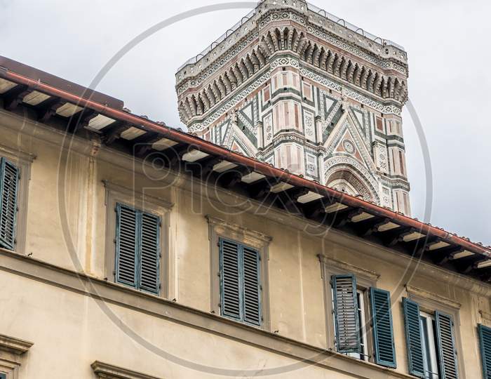 Italy,Florence, A Large Brown Clock Tower In Front Of A Building