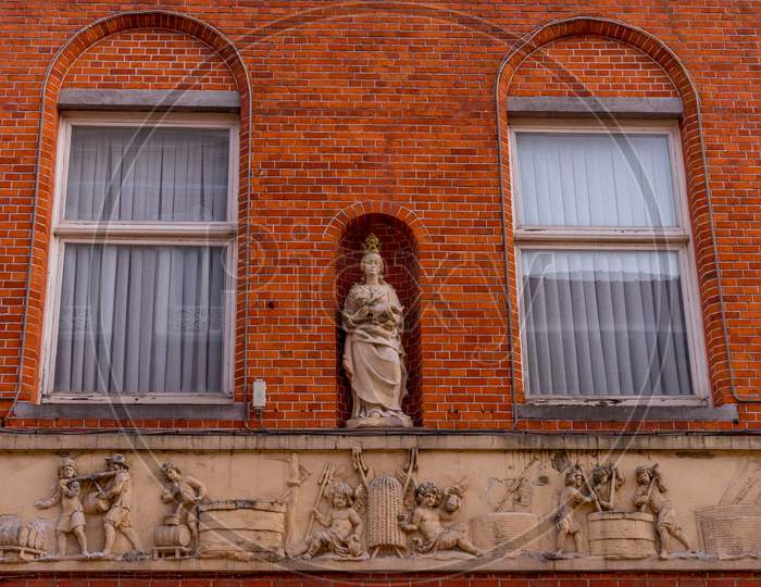 Belgium, Bruges, A Close Up Of A Brick Building With Madonna Statue