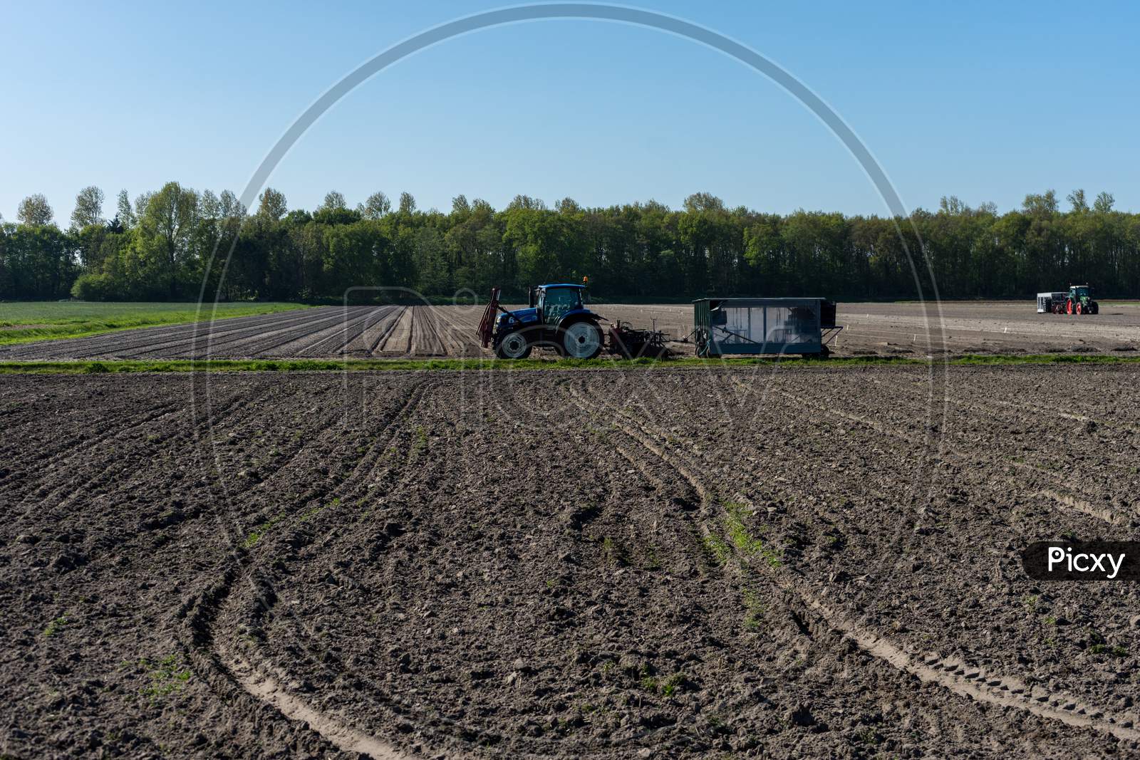 Lisse, Netherlands - 5 May 2018: A Farmer Ploughing His Field Using A Tractor