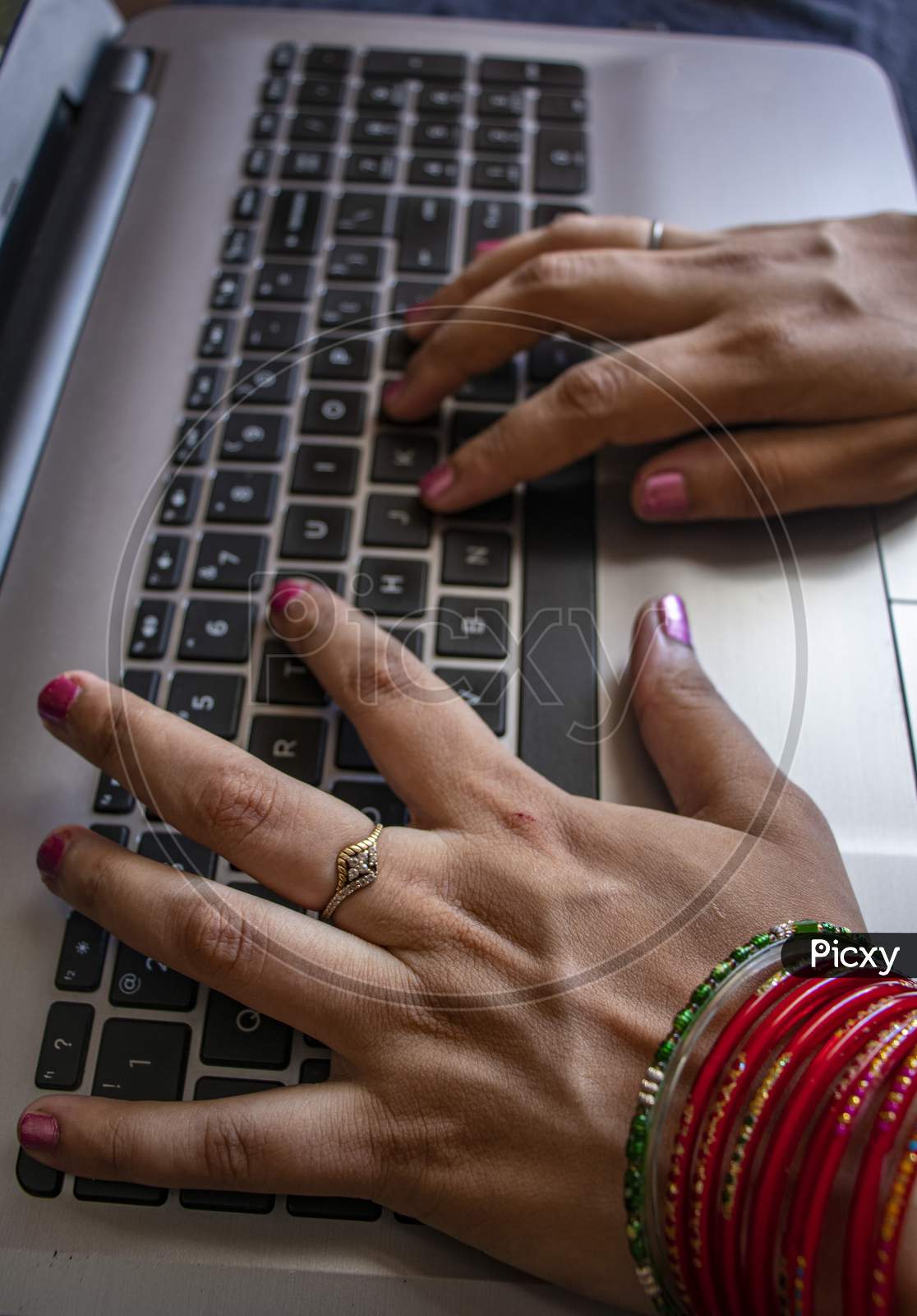 indian Female Working From Home. Wearing Bangles.