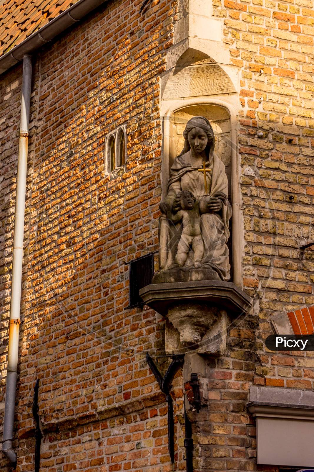 Belgium, Bruges, Madonna And Baby Jesus Sculpture On A Building Wall