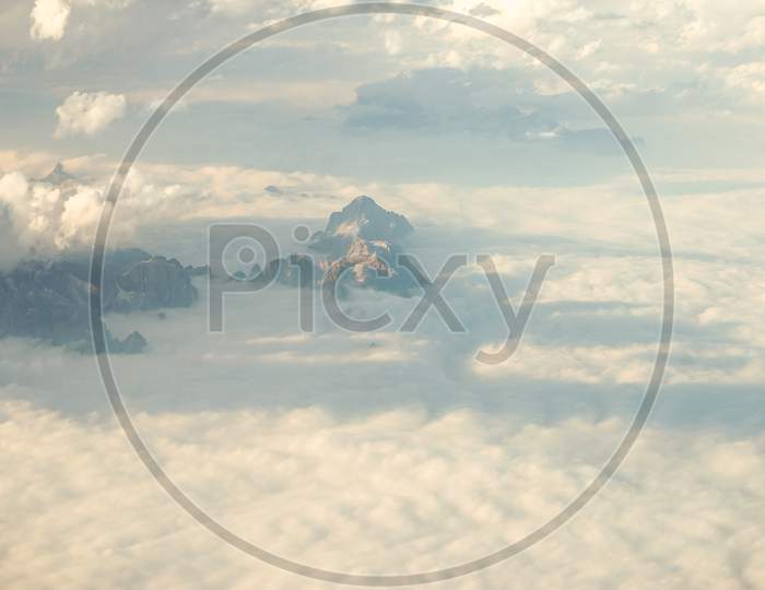 Clouds Over Snow Clad Austrian Alps Mountains Seen From An Airplane Window