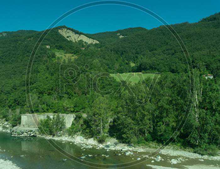 Italy,La Spezia To Kasltelruth Train, A Body Of Water Surrounded By Trees