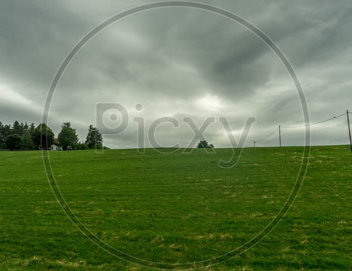 Italy,La Spezia To Kasltelruth Train, A Large Green Field With Clouds In The Sky