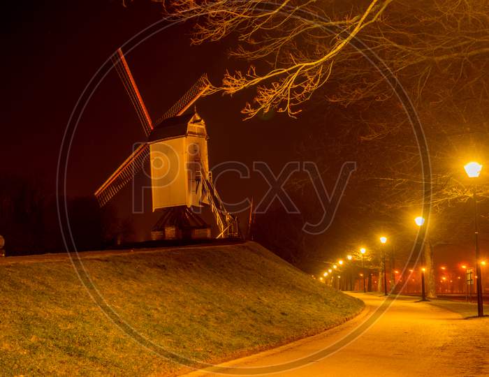 Belgium, Bruges, A Close Up Of A Street At Night With Windmill