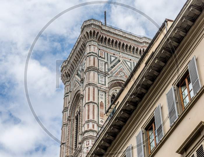 Italy,Florence, A Large Tall Tower With A Clock On The Side Of A Building