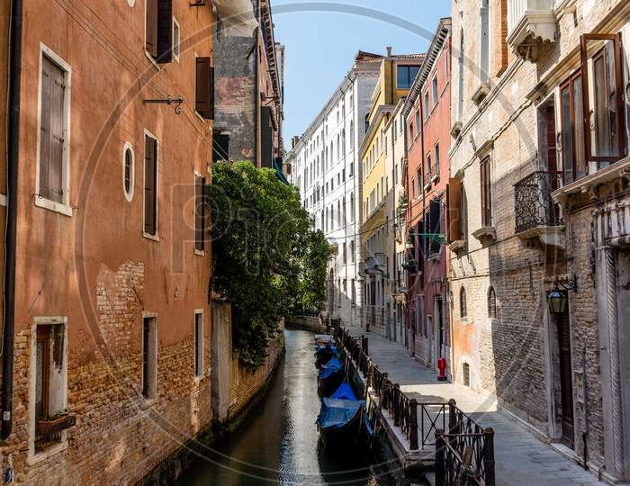 Italy, Venice, A Narrow City Street With Old Buildings In The Background