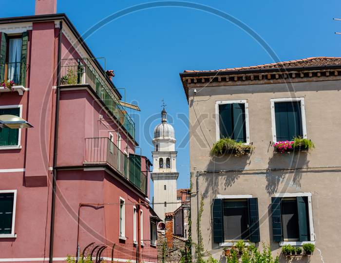 Italy, Venice, A Large Brick Building With A Clock On The Side Of A House