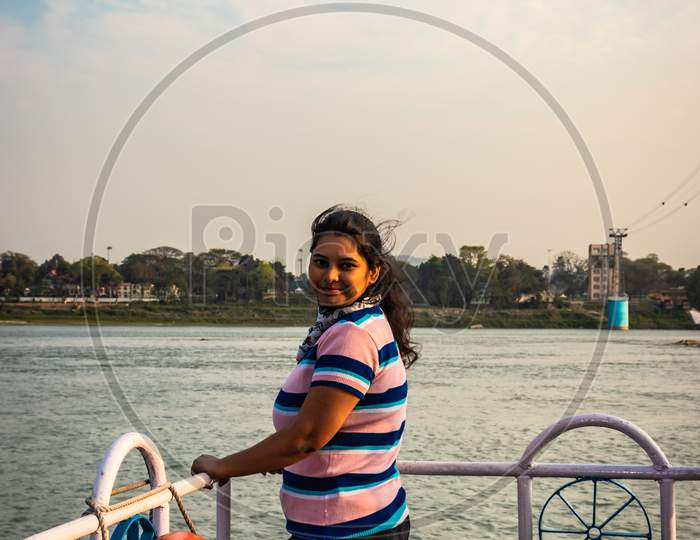 Girl Posing At Ship Deck With River Horizon At Evening