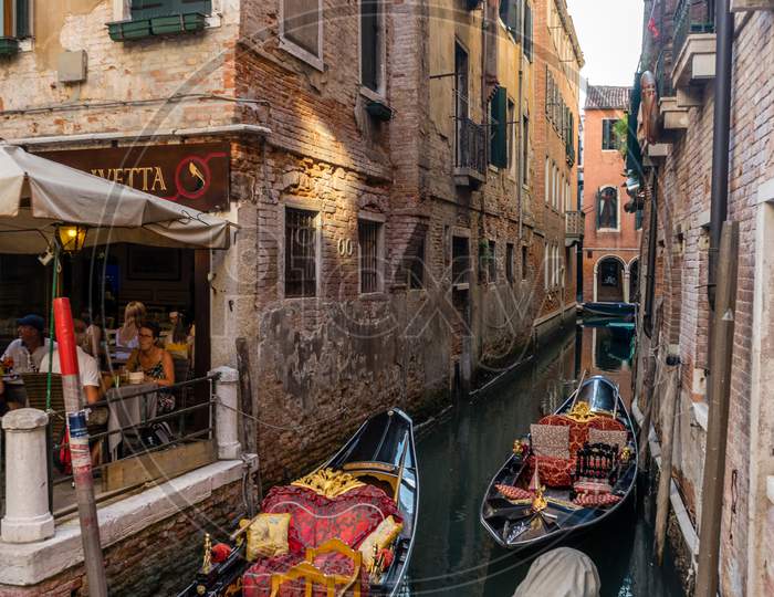 Venice, Italy - 30 June 2018: The Gondolas Parked With Gondolier Near Bridge In Venice, Italy