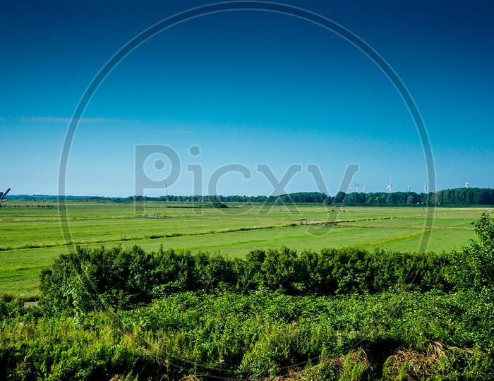 Netherlands, South Holland, A Large Green Field With Trees In The Background