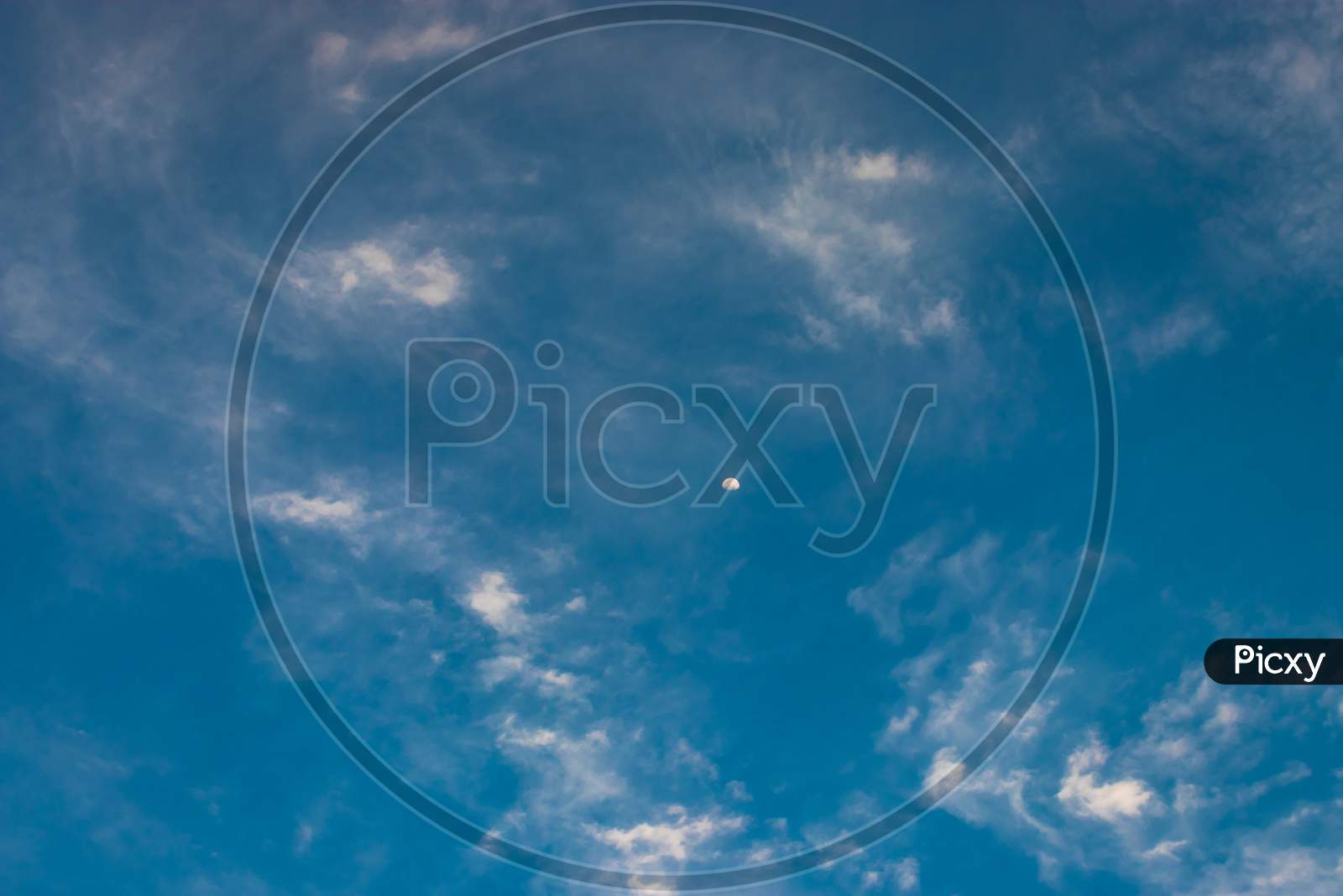 Moon With Bright Blue Sky And Clouds At Morning