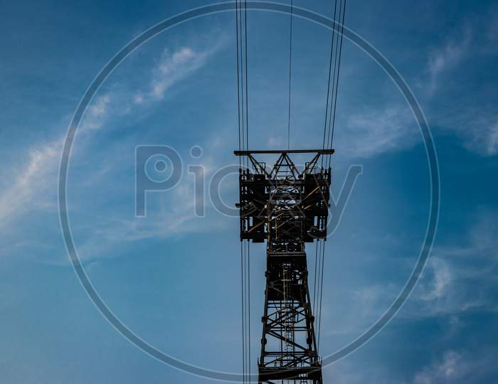 Electric Power Transmission Line With Bright Blue Sky Background
