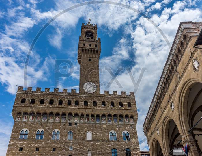 Italy,Florence, Palazzo Vecchio, A Large Tall Tower With A Clock On The Side Of Palazzo Vecchio