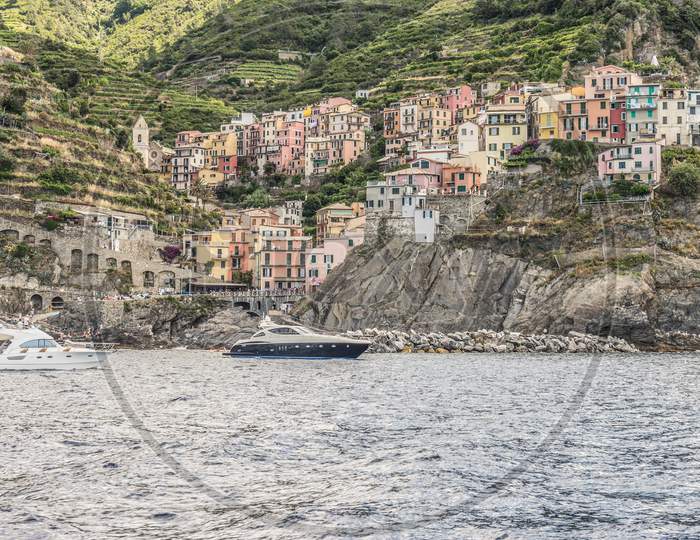 Italy, Cinque Terre, Riomaggiore, Manarola, Sailboats In Sea Against Buildings In City