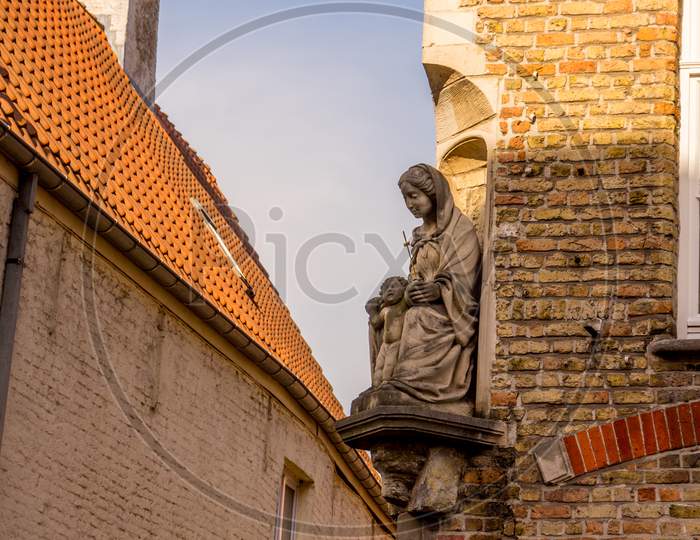 Belgium, Bruges, Madonna And Baby Jesus Sculpture On A Building Wall