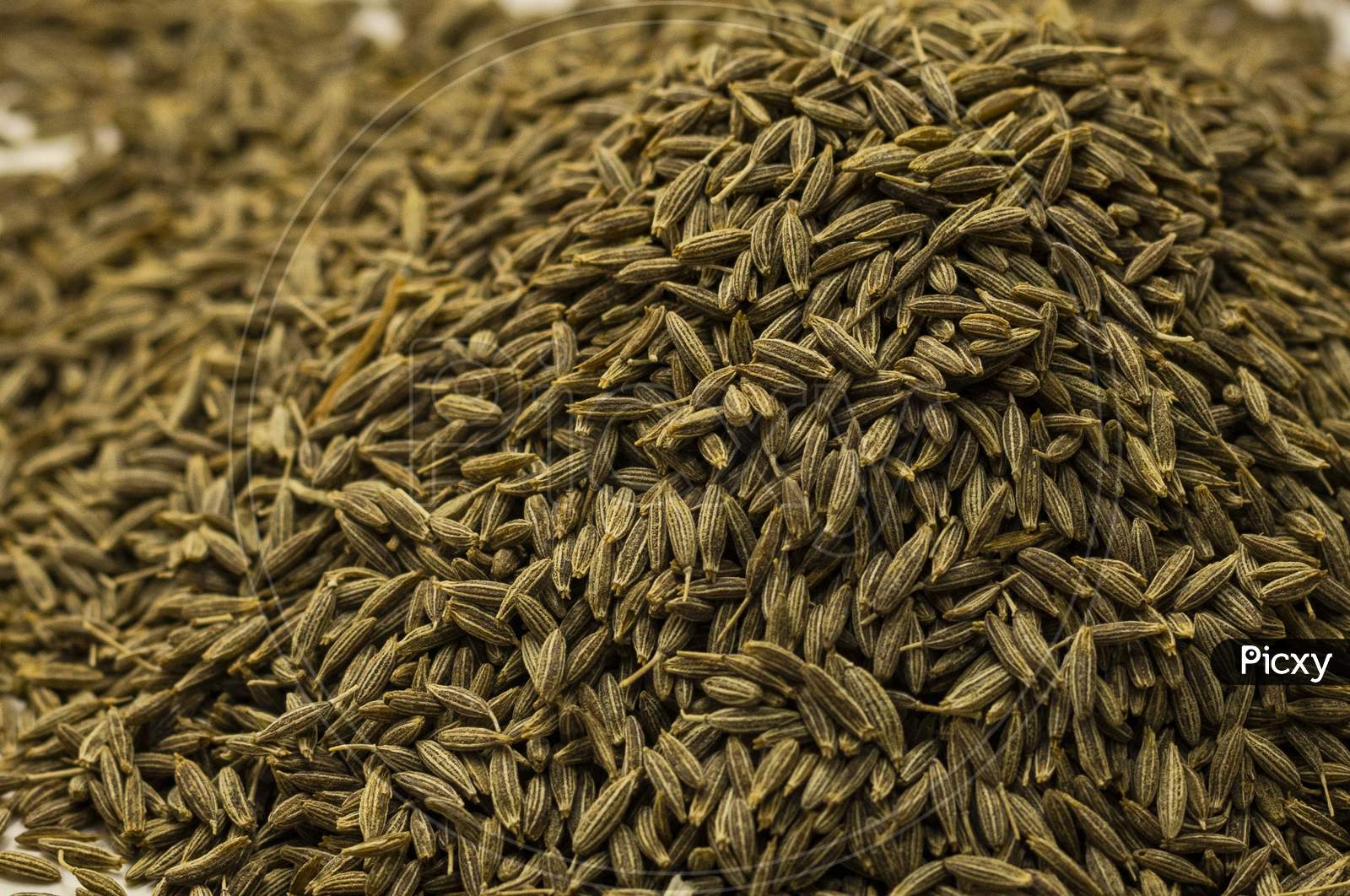 Cumin seeds or caraway seeds. Surface covered with cumin seeds.