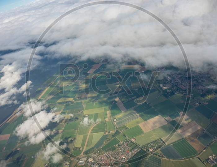 Farms In Holland, Netherlands With Canal Viewed From Plane In Sky