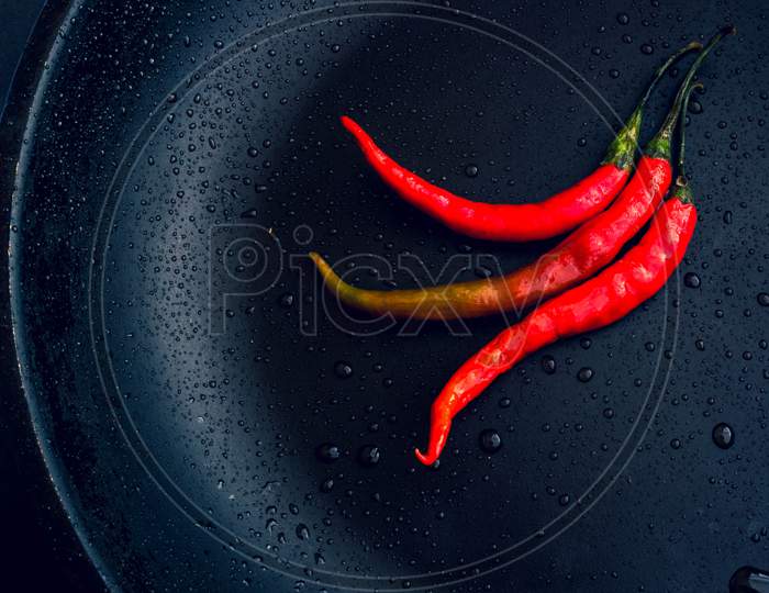 Three red chillies in a pan
