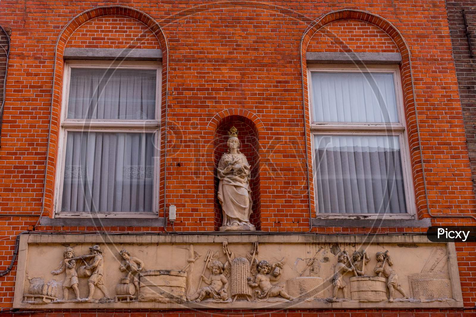 Belgium, Bruges, A Close Up Of A Brick Building With Madonna Statue