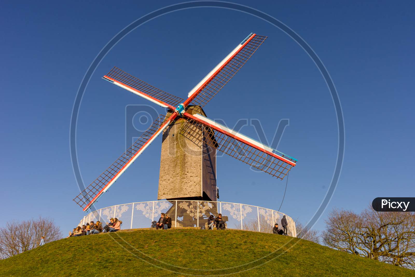 Belgium, Bruges, A Windmill On Top Of A Grass Covered Field