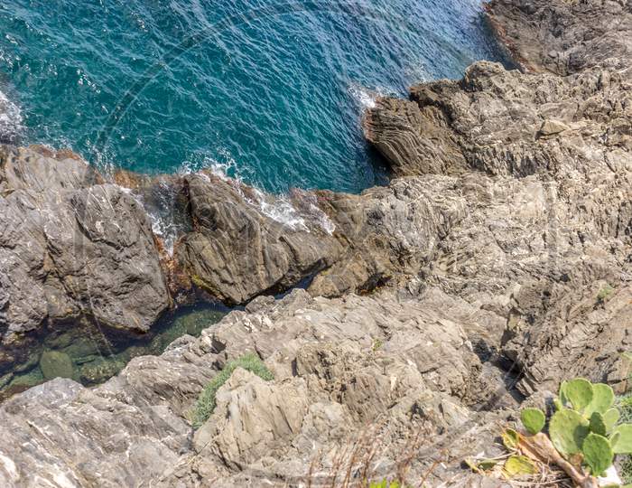 Italy, Cinque Terre, Manarola, A Close Up Of A Rock Next To Water